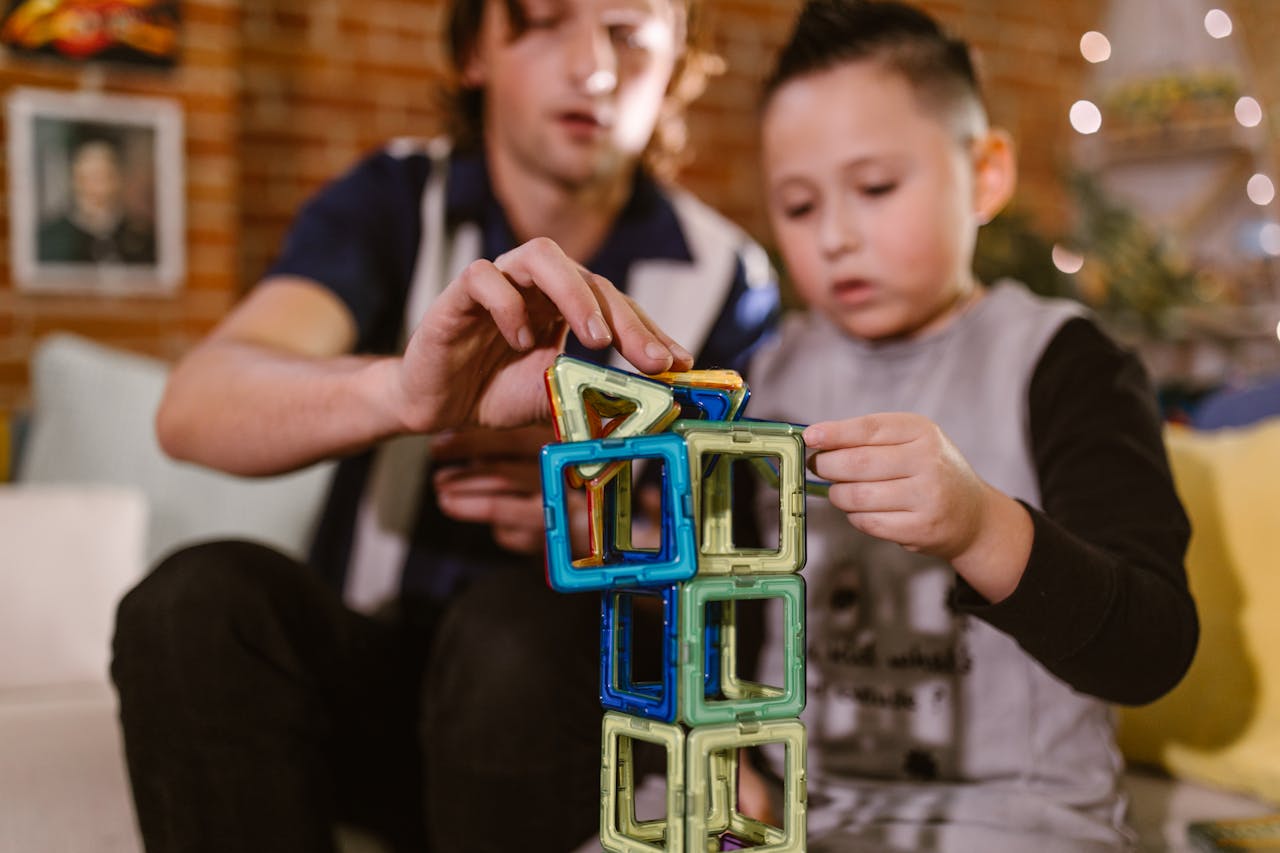 A father and son enjoying quality time building a tower with colorful magnetic blocks.